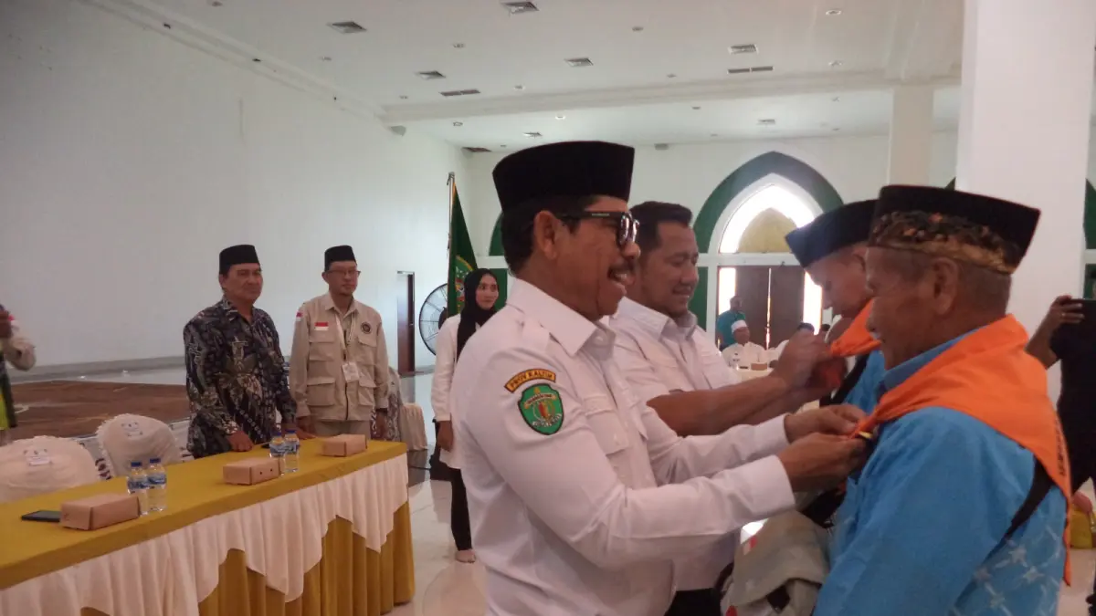 Mudyat Noor bersama Waris Muin menyematkan syal haji kepada Muhammad Naufal Al Mubarak dan Dunani Gendut Tuntak saat pelepasan jemaah haji asal PPU di Masjid Agung Al Ikhlas Islamic Center PPU, Rabu (6/5/2026). (AHMAD MAKI/KALTIM POST)