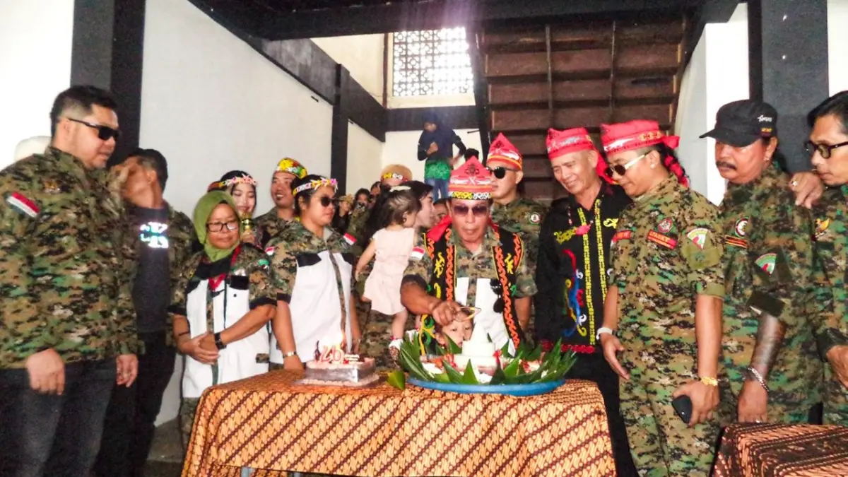 SYUKURAN: Nasion Lasung, memotong tumpeng dalam seremonial HUT LPADKT yang dihelat di Pujasera Lamin, Pantai Manggar Segara Sari, Minggu (10/5/2026). IST/KP