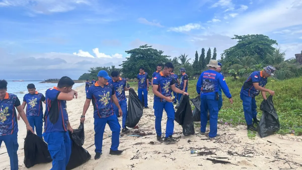 BERSIH PANTAI: Masyarakat dan personel Ditpolairud Polda Kaltim memungut sampah sekitar pesisir pantai Pelabuhan Semayang. IST/KP