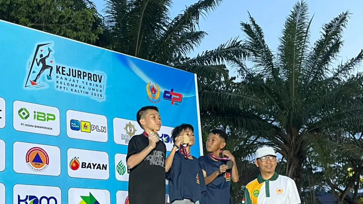 BOLEH BANGGA: Kepala Bidang Peningkatan Prestasi Olahraga Dispora Kaltim, Razman Rading saat mengalungi para pemenang di Kejurprov KU 2026. (FOTO: NASYA RAHAYA)