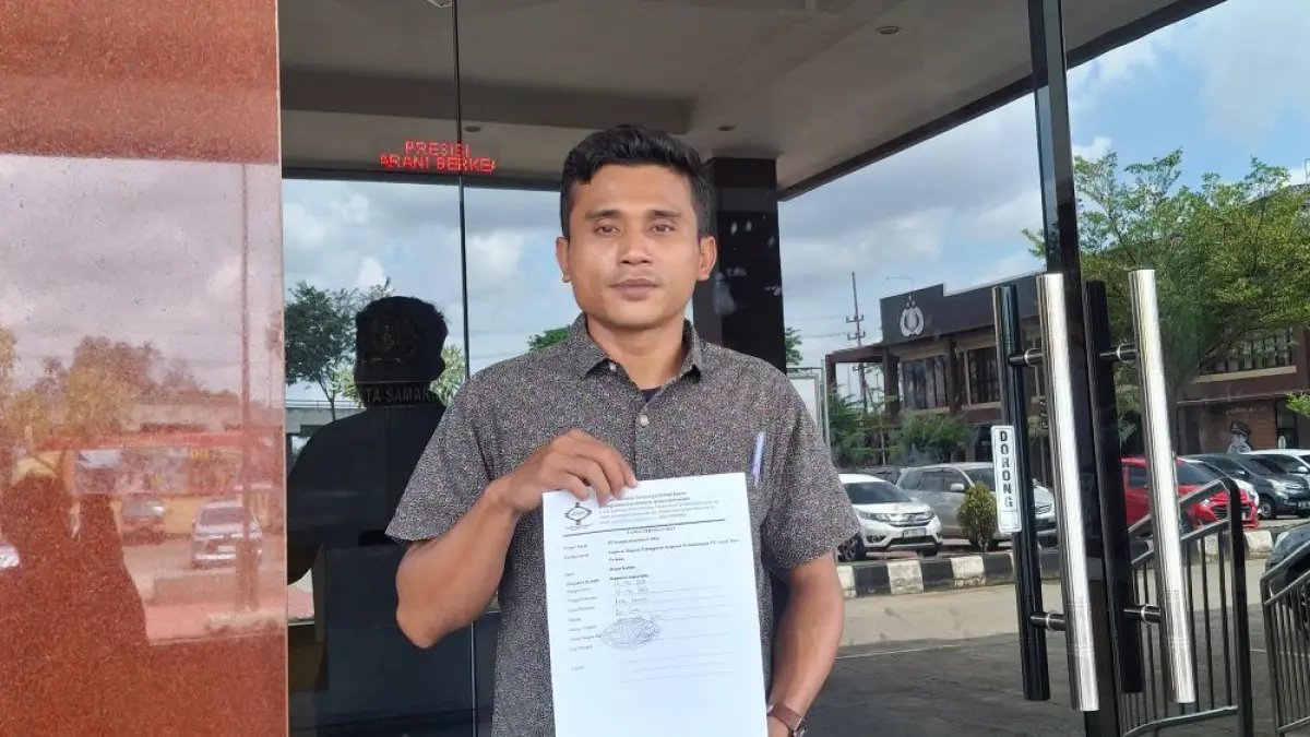 Dinamisator Jatam Kaltim Mustari Sihombing menunjukkan bukti pelaporan dugaan pidana kelalaian perusahaan tambang di Samarinda.