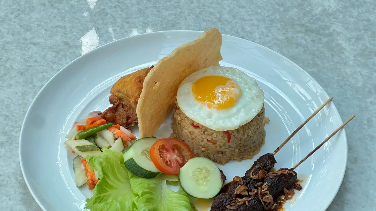 LENGKAP: Nasi goreng spesial disajikan lengkap dengan ayam, sate daging, telur mata sapi, acar serta pilihan sosis sapi dan sosis ayam yang memberikan rasa gurih dan tampilan menggugah selera.