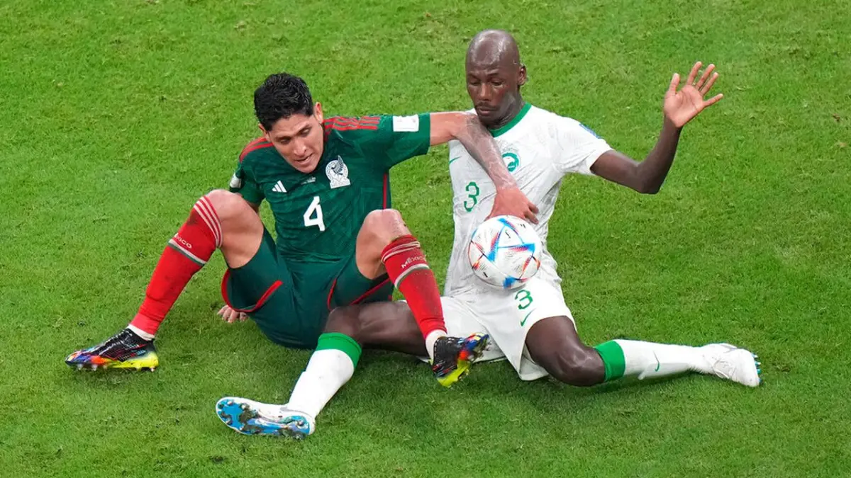 Pemain Meksiko Edson Alvarez berebut bola dengan bek Arab Saudi Abdullah Madu dalam laga Grup C Piala Dunia 2022 di Stadion Lusail, Qatar. Meksiko menang 2-1 namun gagal lolos ke babak 16 besar. (AP Photo/Luca Bruno)