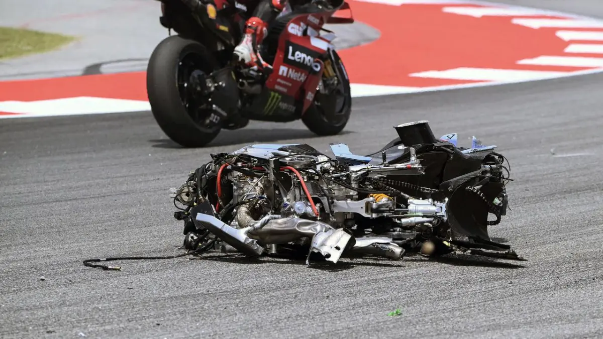 Kondisi motor yang rusak parah usai insiden keras di MotoGP Catalunya membuat marshal langsung mengibarkan bendera merah. (AFP/Daniel Ballarin)