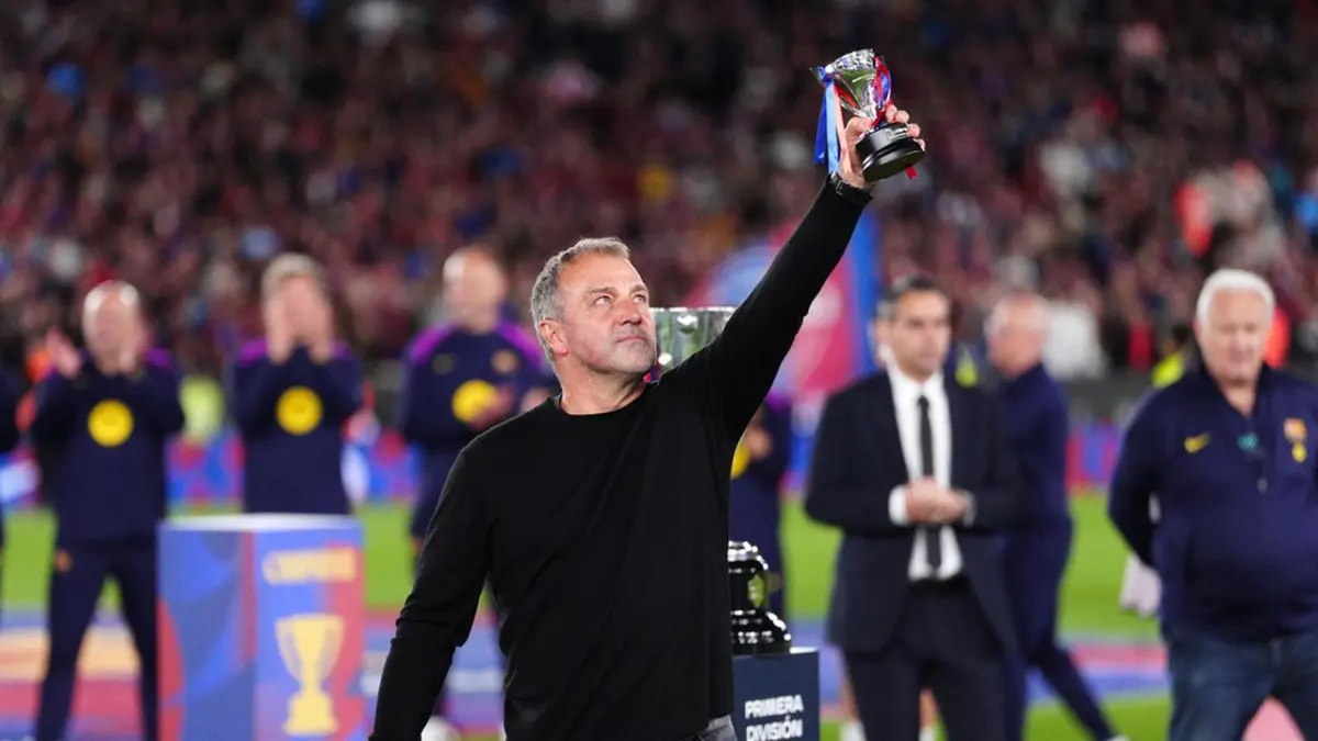 Pelatih FC Barcelona, Hansi Flick, mengangkat trofi La Liga usai kemenangan 2-0 atas Real Madrid CF di Barcelona, Spanyol, Minggu (10/5/2026). (AP Photo/Joan Mateu Parra)