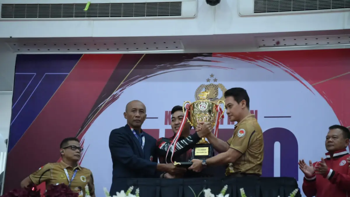 KAMPIUN: Irjen Polisi Daniel Adityajaya (kanan) menyerahkan piala bergilir kepada atlet Bareskrim Polri yang berhasil menjadi juara umum Kapolri Cup 2026. (DONI/KP)