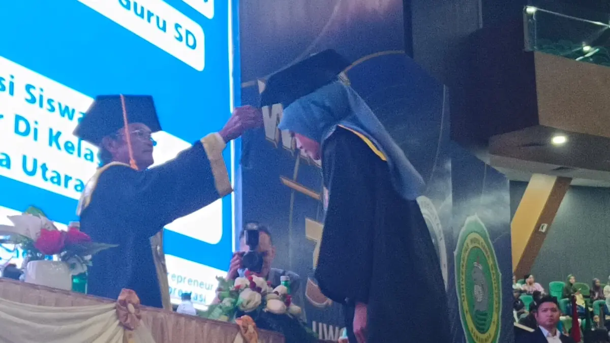 TALI TOGA: Rektor UWGM Samarinda, Prof Dr Husaini Usman (kiri) saat memindahkan tali toga salah satu peserta wisudawan kemarin.
