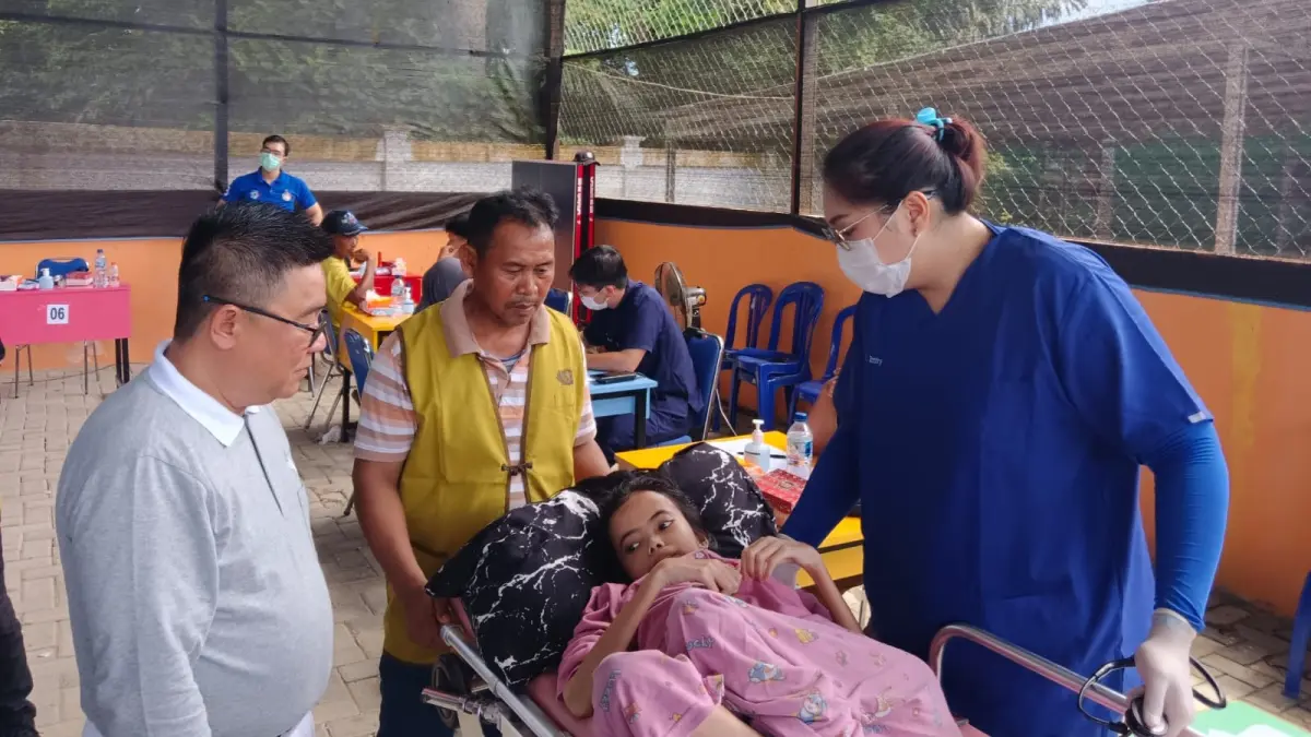 PEMERIKSAAN: Senior Tzu Chi, Xie Li Kaltim 3, Darmawan Rijadi (kiri) menyaksikan pemeriksaan yang dilakukan dr Santy Isabela Tantry (baju biru) kepada salah satu warga Desa Benua Baru. (AKBAR/KP)