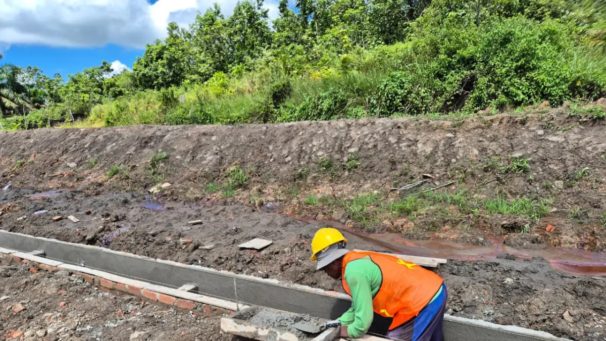 FINISHING: Pekerja sedang menuntaskan pembangunan cable duct dengan pekerjaan perapihan dan finishing permukaan saluran beton.

&nbsp;