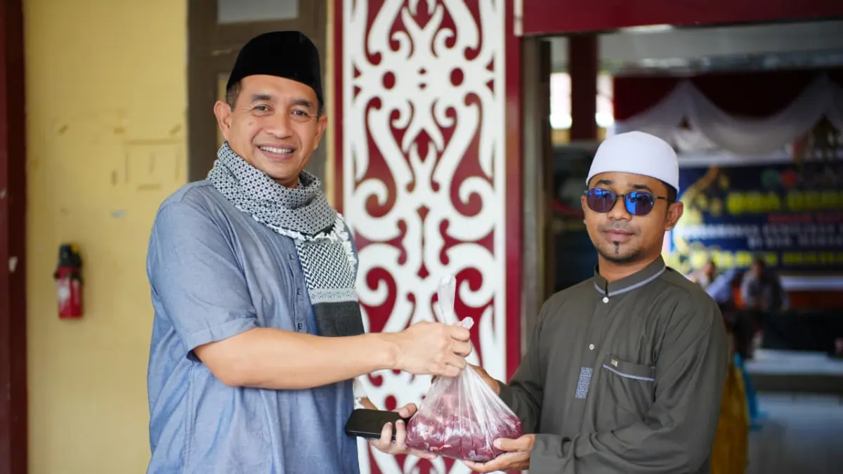 Kapolres Mahulu AKBP Eko Alamsyah (kiri) memberikan paket daging kurban kepada warga sekitar, Rabu (27/5). JODY KRISTIANTO/KP