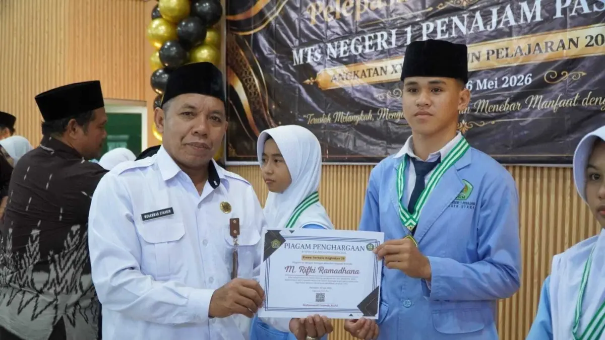 PIAGAM: Kepala Kemenag PPU, Muhammad Syahrir (kiri) menyerahkan piagam penghargaan kepada 10 besar pelajar MTsN terbaik.(ist)