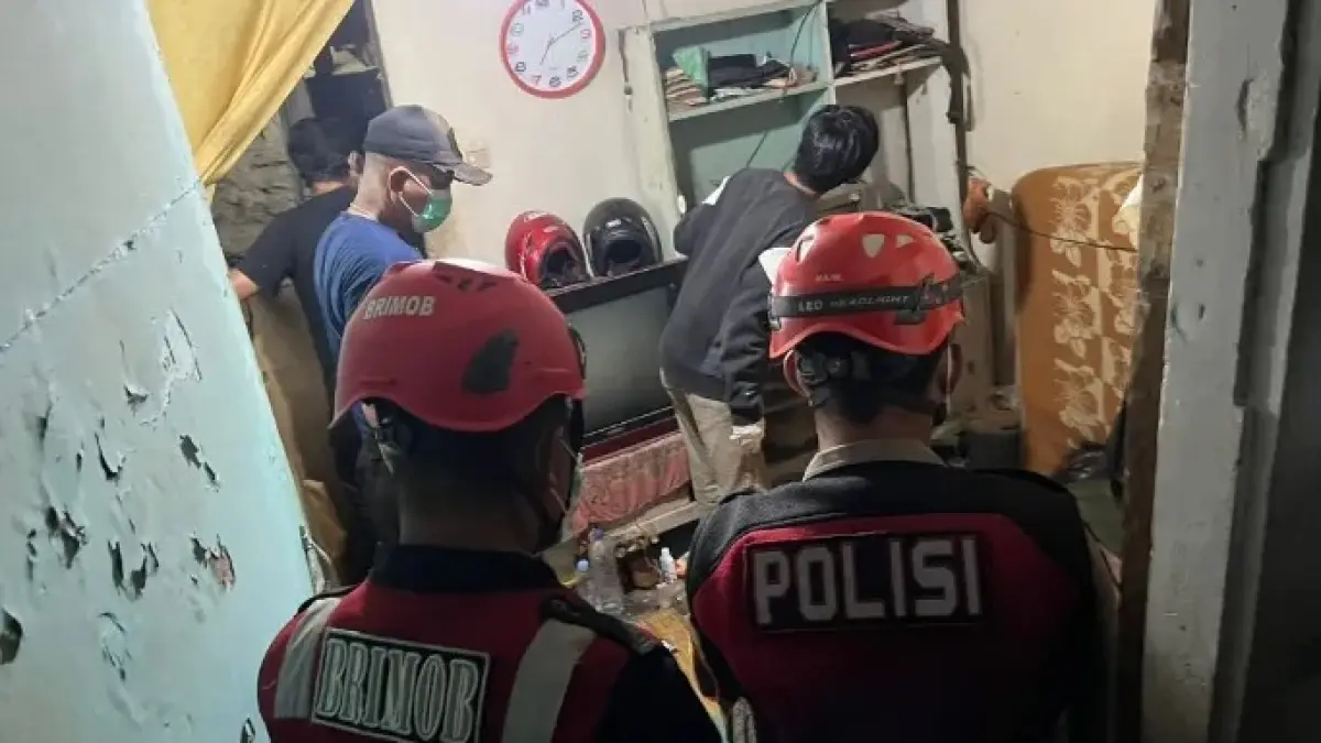 EVAKUASI: Petugas melakukan evakuasi korban yang ditemukan meninggal di dalam rumahnya.
