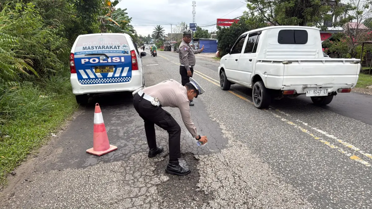 CAT: Personel Satlantas Polres PPU menandai jalan berlubang dengan cat warna mencolok untuk menjadi perhatian warga yang melintas di jalan trans Kaltim-Kalsel tersebut untuk lebih berhati-hati.(humas polres ppu).