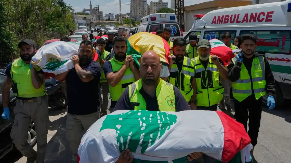 PROSESI PEMAKAMAN: Paramedis dan warga membawa jenazah korban serangan udara Israel saat prosesi pemakaman di kota Tyre, Lebanon. Korban tewas saat melarikan diri dari desa mereka. (AP)