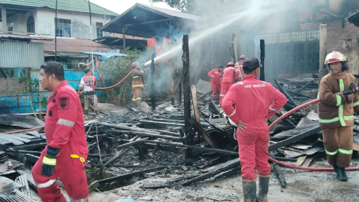 BERJIBAKU: Petugas saat melakukan pemadaman api di Samboja Barat.