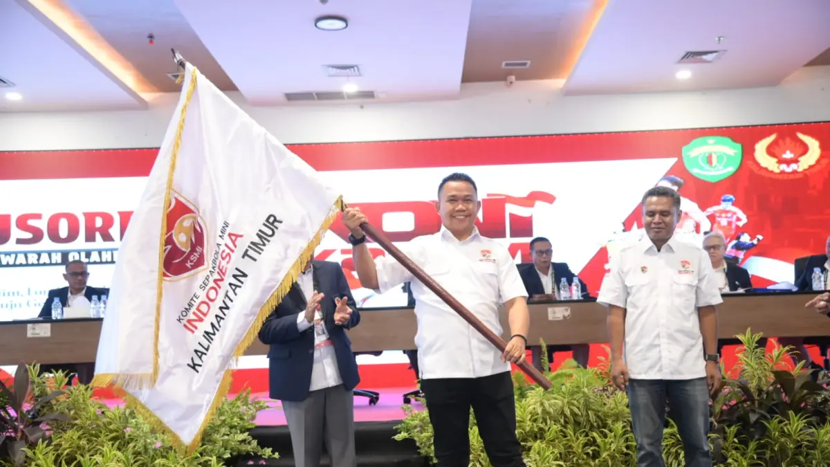 SIAP BERPRESTASI: Haji Ari mengibarkan bendera KSMI sesaat setelah diresmikan sebagai anggota KONI Kaltim.&nbsp;