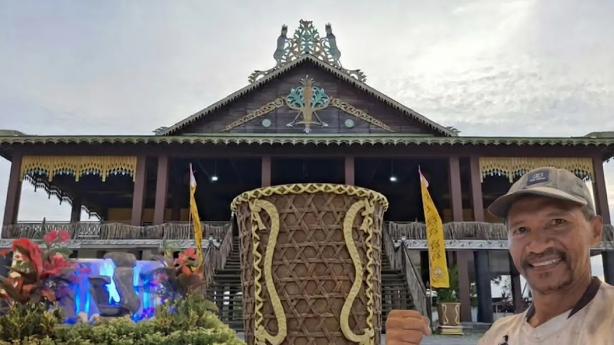 POT SOLONG: Penggiat lingkungan PPU, Masrani, bersama pot bunga bermotif Solong Tengkalang hasil karyanya yang diletakkan di halaman depan Rumah Adat Paser, PPU.(IST)