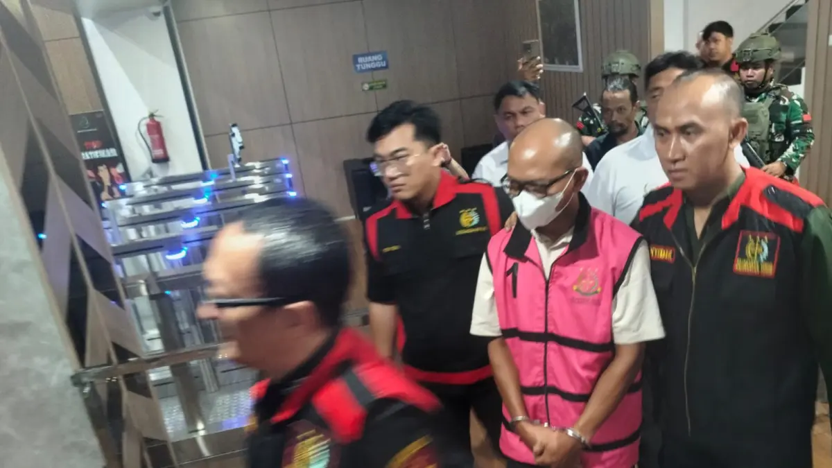Tersangka AW (tengah) dengan rompi tahanan pidsus saat digiring petugas Kejati Kaltim menuju mobil tahanan untuk dijebloskan ke Rutan Kelas I Samarinda, Selasa (9/6/2026) malam. (BAYU/KP)