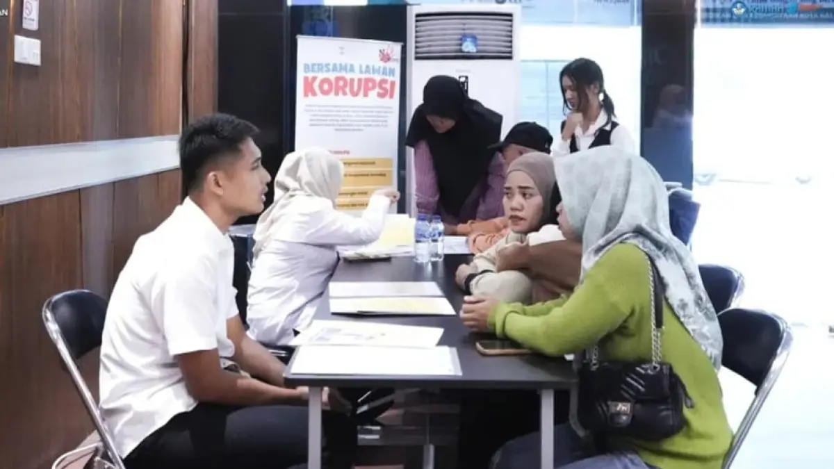 SERIUS: Petugas Disdikbud Balikpapan memberikan penjelasan mengenai petunjuk teknis (juknis) pendaftaran kepada salah satu orang tua siswa di posko informasi SPMB Balikpapan 2026.