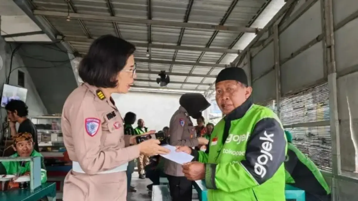 BERBAGI: Personel Polwan Ditlantas Polda Kaltim berbagi pada pengemudi ojol Balikpapan.