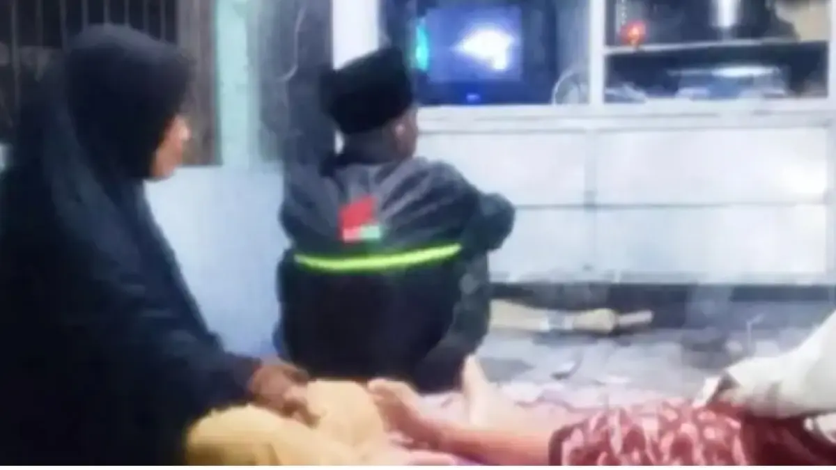 Perempuan berinisial En (53) menjadi sorotan setelah fotonya saat berjaga di pos kamling Desa Watuagung, Kecamatan Prigen, Pasuruan, viral di media sosial. (Foto tangkapan layar)