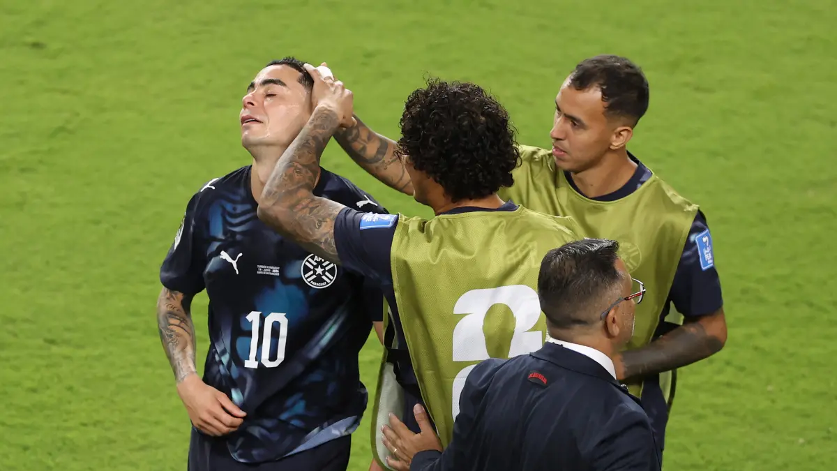 Pemain Paraguay menghibur Miguel Almiron (kiri) yang diganjar kartu merah karena menutupi mulutnya saat berdebat dengan lawan. (STU FORSTER/AFP)