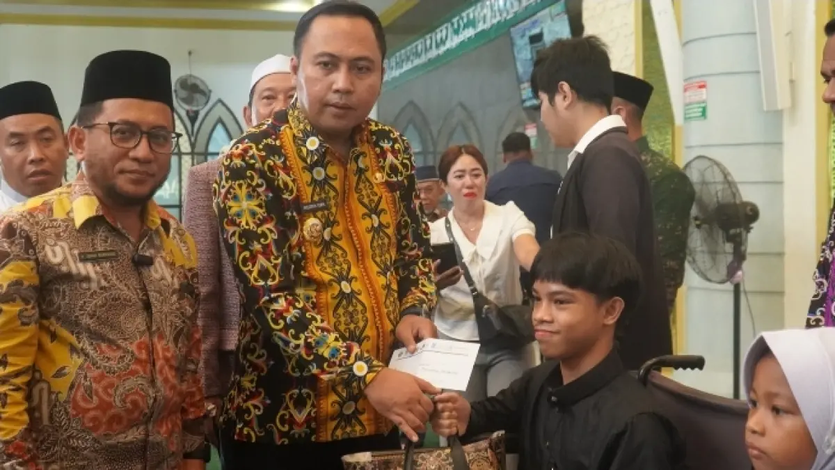 BANTUAN: Bupati Kutai Barat Frederick Edwin saat menyerahkan bingkisan untuk anak yatim dan disabilitas.