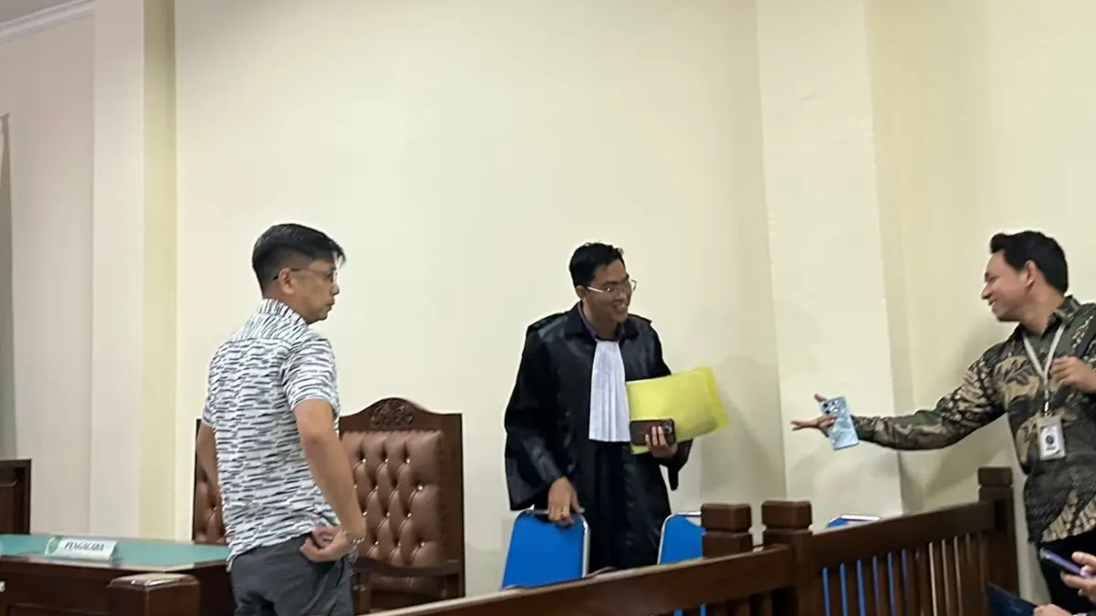 MINTA BEBAS: Terdakwa Handi Aliansyah berdiskusi dengan kuasa hukumya di sela sidang pembacaan duplik kasus dugaan penipuan bisnis solar Rp 20 miliar di PN Balikpapan.&nbsp;