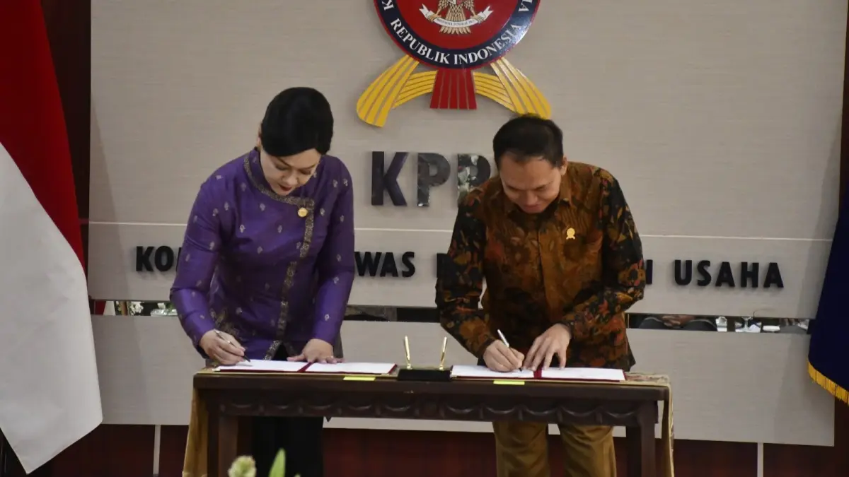 SINERGI: Ketua KPPU M. Fanshurullah Asa (kanan) dan Ketua Dewan Komisioner OJK Friderica Widyasari Dewi menunjukkan dokumen Nota Kesepahaman (MoU) usai penandatanganan di Kantor KPPU, Jakarta, Senin (6/7). (IST)
