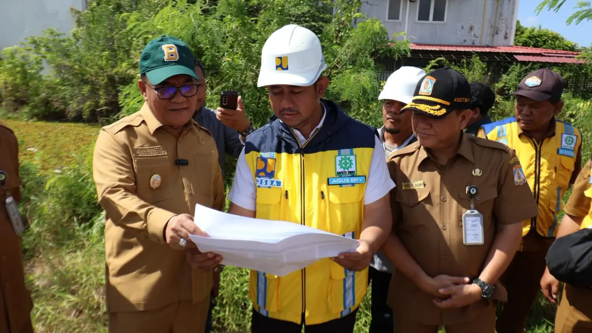 TINJAU PROYEK BANJIR: Wakil Wali Kota Balikpapan, Bagus Susetyo (kiri) melakukan kunjungan lapangan ke lokasi pembangunan Bendali Hulu Sungai Ampal di belakang Pasar Segar, Selasa (7/7/2026).