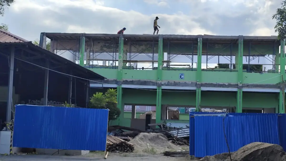 KEJAR TARGET: Beberapa tukang terlihat beraktivitas di atas gedung kelas SMP 2 Samarinda Jalan Ahmad Dahlan Kecamatan Samarinda Kota, yang terbakar April lalu, Jumat (10/7). (DENNY SAPUTRA/KP)