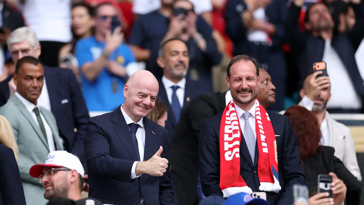 Putra Mahkota Norwegia, Haakon (kanan), berbincang dengan Presiden FIFA, Gianni Infantino, saat menyaksikan pertandingan perempat final Piala Dunia 2026 antara Inggris dan Norwegia. (JUSTIN SETTERFIELD/AFP)