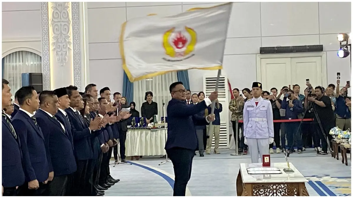 Anderiy Syachrum mengibarkan pataka usai dilantik sebagai Ketua KONI Kaltim. (SAPOS)