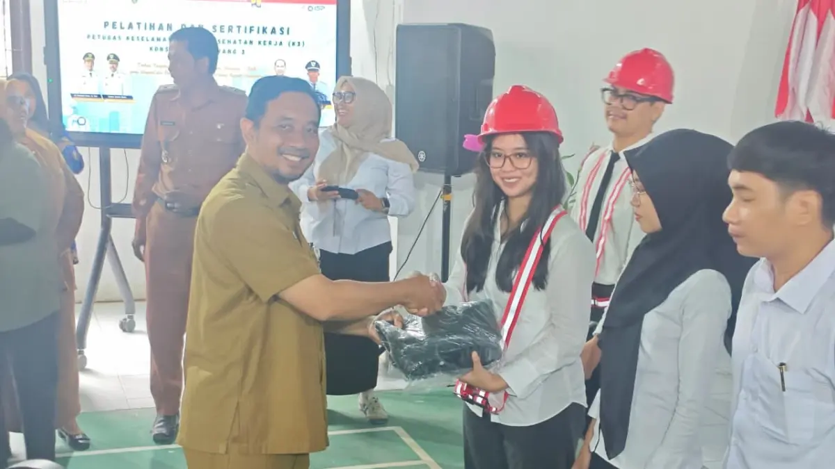 SERTIFIKASI: Sekretaris Dinas PUPR PPU, M Ali Musthofa menyerahkan alat pelindung diri kepada salah satu peserta dalam pembukaan serentak di Balai Desa Labangka pada 2 Juni 2026.