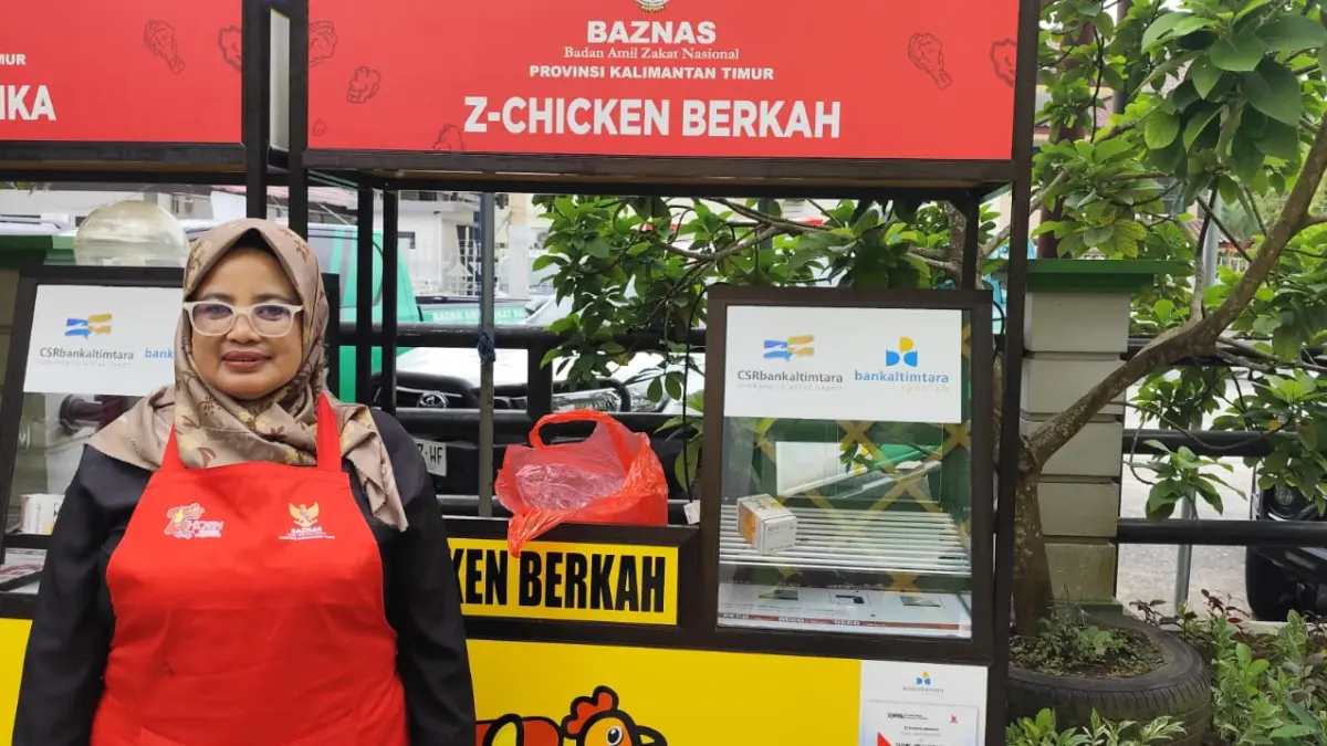 DUKUNGAN: Tutut Dwi Arti berdiri di depan booth jualan ayam krispi yang diberikan Baznas Kaltim, Selasa (22/7). DENNY SAPUTRA/KP