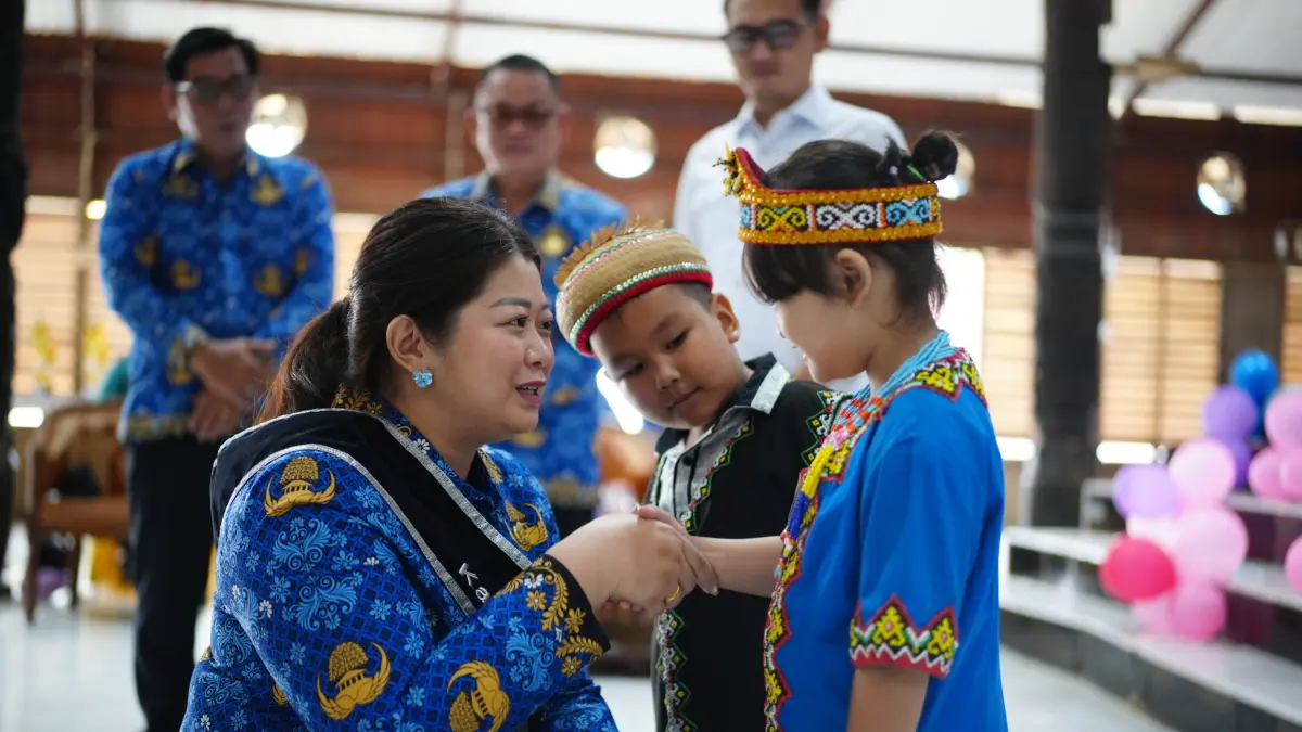 BERHARGA: Bupati Mahulu Angela Idang Belawan menyematkan nomor peserta lomba dalam rangka perayaan HAN di Balai Adat Ujoh Bilang, Kamis (23/7). JODY KRISTIANTO/KP