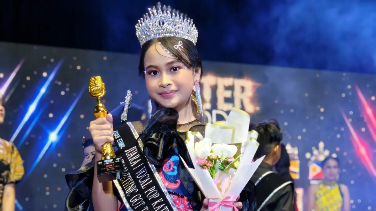 TALENTA: Kauren Atiqa Zahira saat mengangkat tropi juara Asian Ethnic Got Talent International 2026 di Jakarta, mengenakan atribut bulu burung ruai khas Kutai.