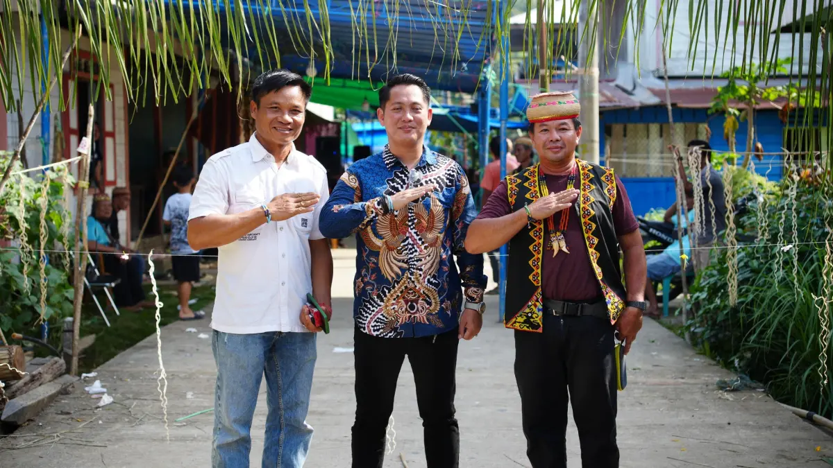 MENGHADIRI: Ketua Komisi II DPRD Mahulu Gohen Merang Sapulete (tengah) Petinggi Kampung Mamahak Besar Alponsius Lawing (kiri) dan Kepala Adat Mamahak Besar (kanan) abadikan momen bersama saat hadiri nikah massal Adat Besar Bahau Busang, Minggu (26/7). (JODY KRISTIANTO/KP)