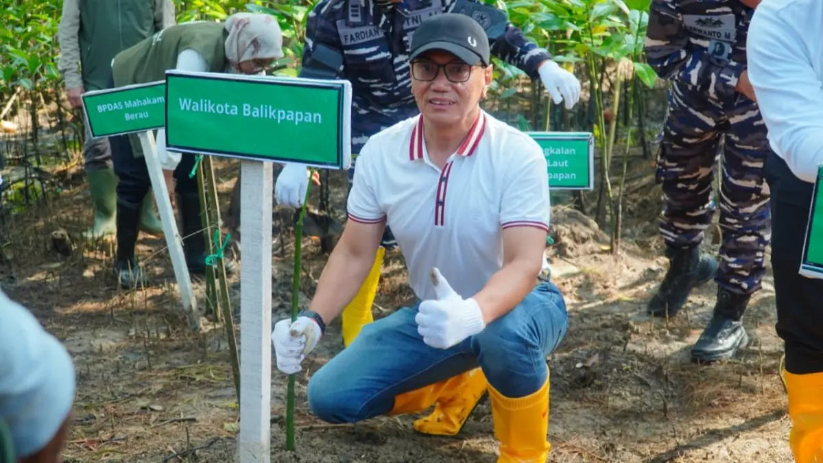 PENANAMAN: Kepala DLH Balikpapan Sudirman Djayaleksana mewakili Wali Kota Balikpapan, melakukan penanaman mangrove secara simbolis pada peringatan Hari Mangrove Sedunia 2026 tingkat Kaltim Pantai Lamaru, Balikpapan, Minggu (26/7).
