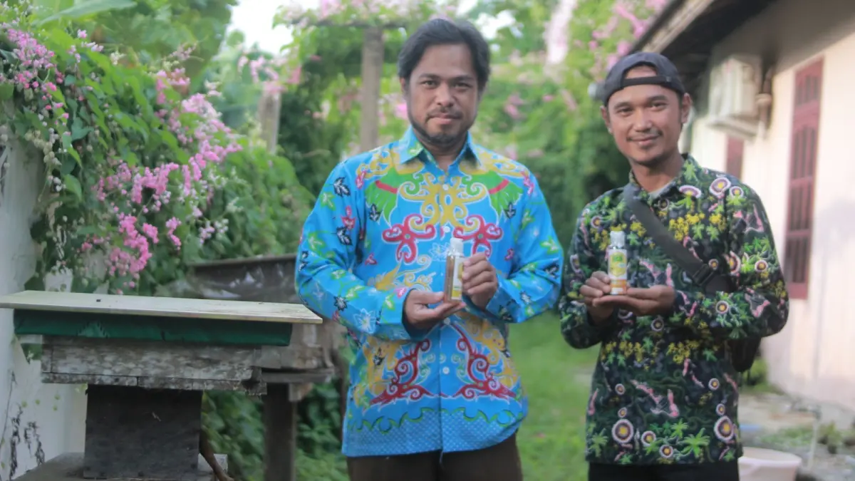 MADU MENTAH: Ahmad Jais (kiri) bersama rekannya Supriyanto menunjukan hasil madu mentahan yang dihasilkan dari koloni stingless bee miliknya.