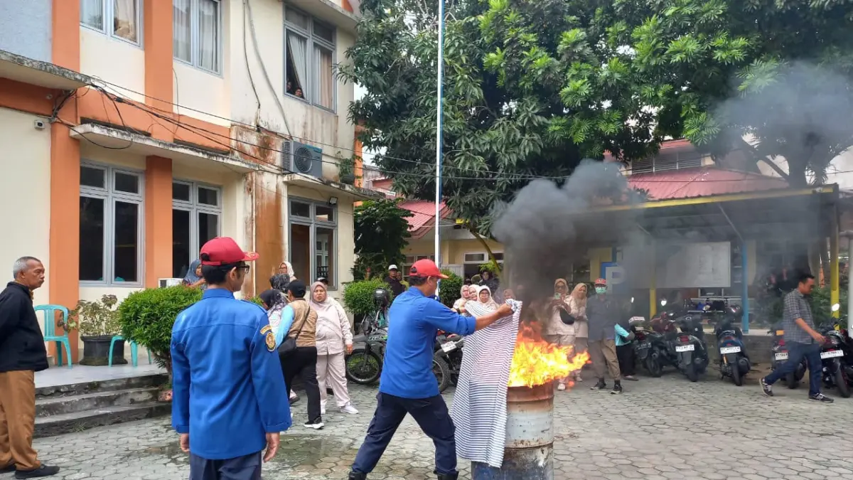 PADAMKAN API: Anggota BPBD Balikpapan memberikan pelatihan cara memadamkan api dengan APAR serta fire blanket kepada warga di Kecamatan Balikpapan Barat.&nbsp;
