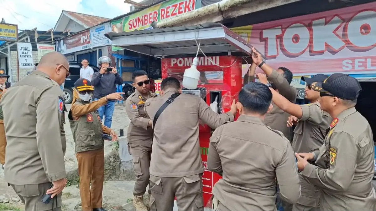 TEGAS: Anis Siswantini (kedua kiri) memantau tim Satpol PP menggeser lapak dispenser BBM ilegal yang berada di tepi jalan Sultan Alimuddin Kecamatan Samarinda Ilir, dalam aksi penertiban, Senin (27/7).