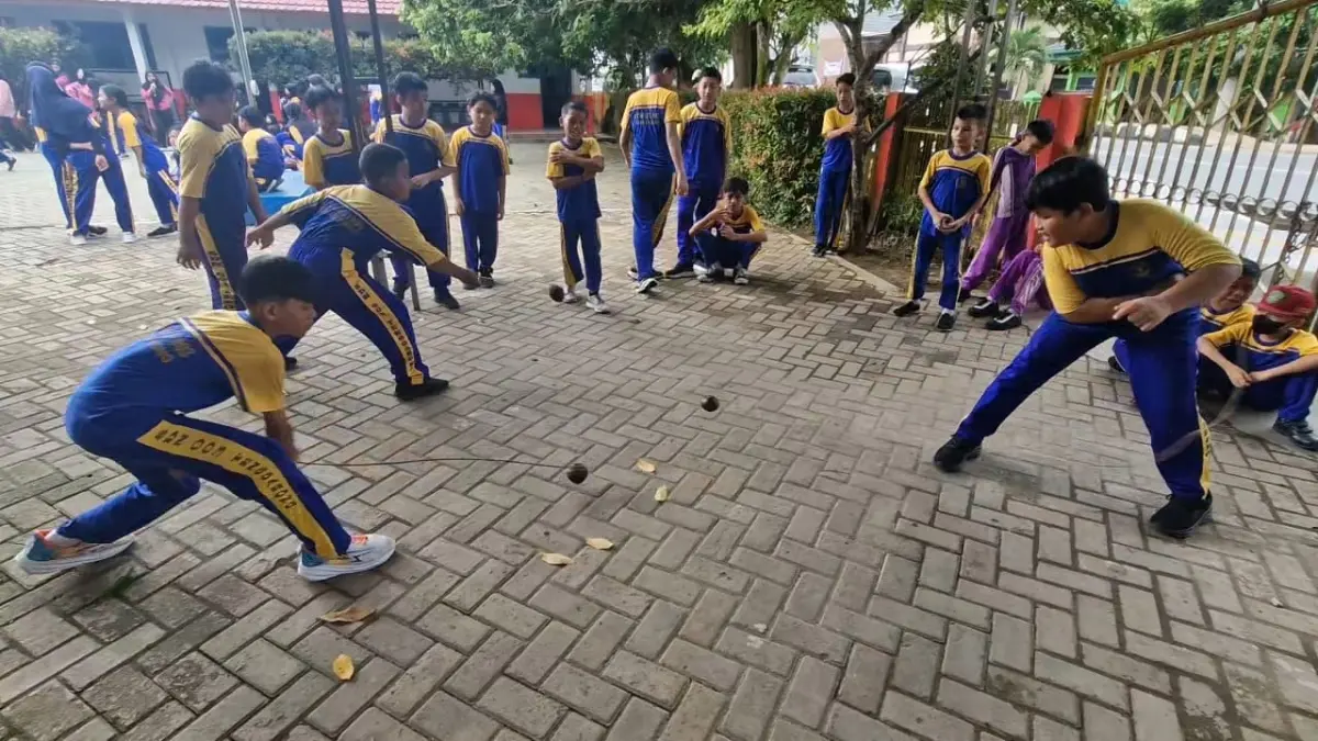 PERMAINAN: Sebanyak lima permainan tradisional, salah satunya gasing kembali diperkenalkan kepada siswa kelas I hingga VI SD Negeri 003 Tenggarong di peringatan HAN.