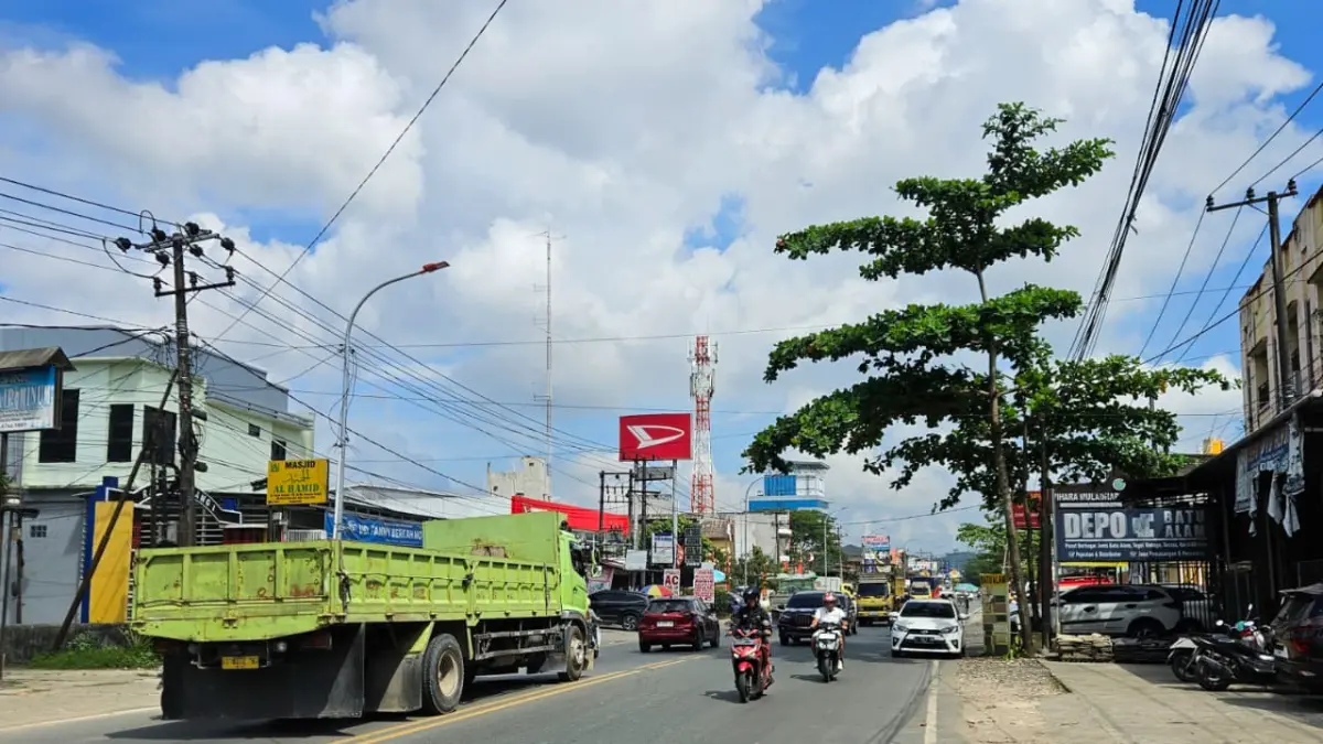DIPENUHI DEBU DAN CECERAN MATERIAL: Suasana lalu lintas di Jalan PM Noor, Samarinda, Kamis (30/7/2026). Ruas jalan ini kerap dipenuhi debu serta ceceran material dari truk angkutan yang membahayakan keselamatan pengguna jalan. (HAFIZ/KP)