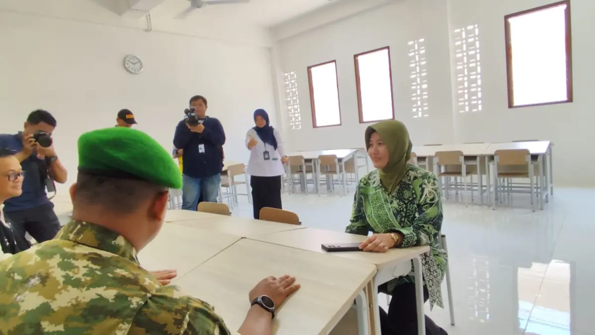 PERIKSA: Neneng Chamelia Shanti (kanan) duduk di meja siswa SRT 2 Samarinda jenjang SD di sela kunjungan lapangan ketika pembukaan MPLS, Jumat (31/7).