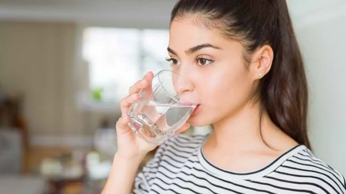 Ilustrasi seorang wanita sedang minum air.(getty images)