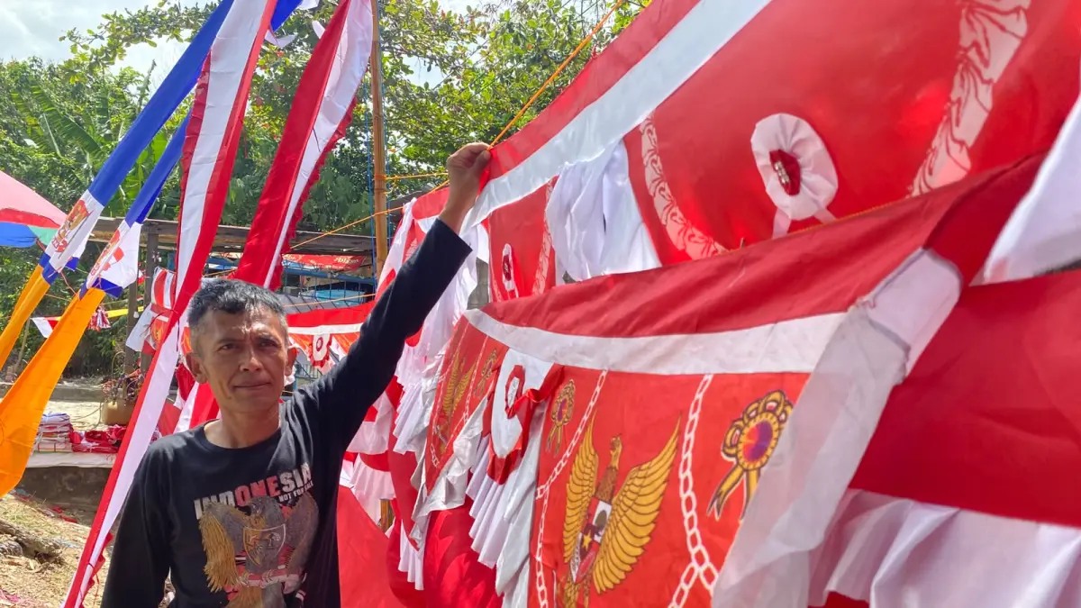 OMZET TURUN: Pedagang bendera musiman menata pernak-pernik dan ornamen Merah Putih di pinggir Jalan Syarifuddin Yoes, Balikpapan Selatan, Senin (3/8/2026). Menjelang HUT ke-81 RI, para pedagang bendera di Balikpapan mengeluhkan penjualan yang merosot tajam hingga lebih dari 50 persen akibat sepinya pembeli dan maraknya penjualan online.