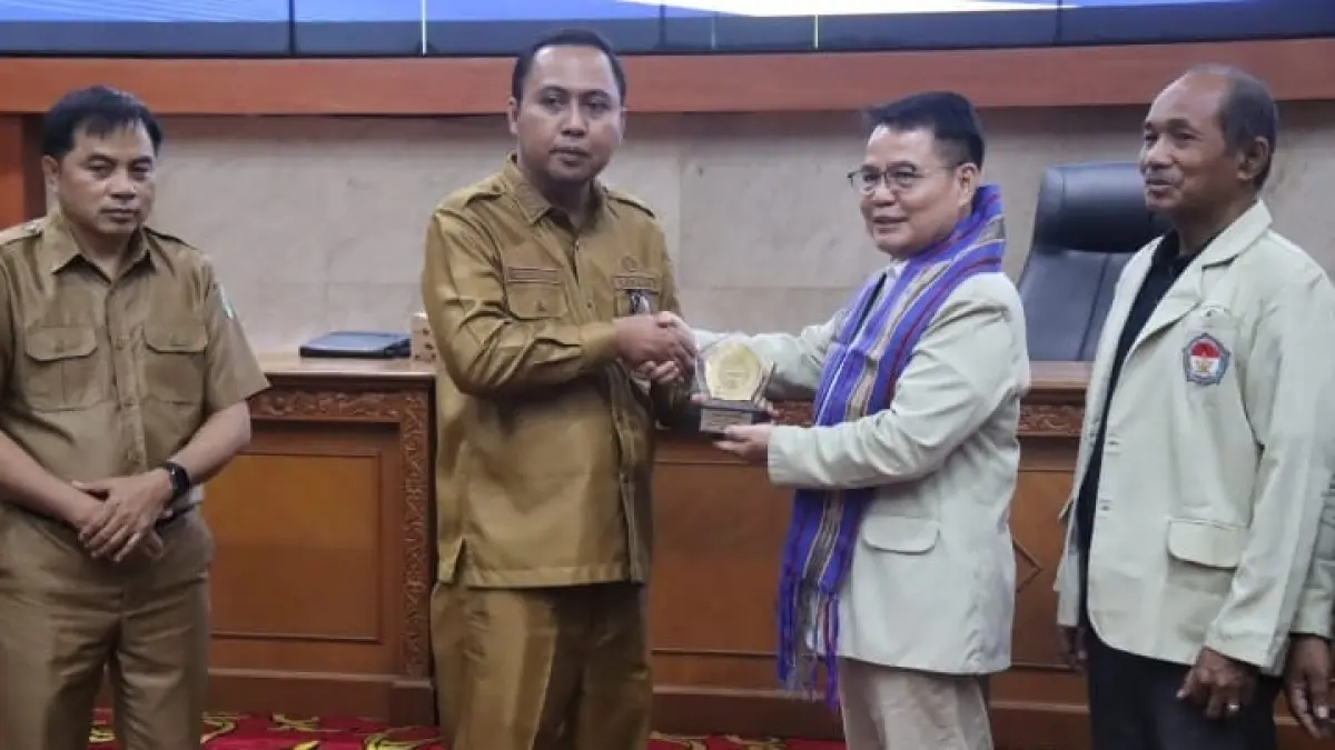 Bupati Kubar, Frederick Edwin (dua kiri) kalungkan cinderamata kepada Ketua STIENAS Samarinda, Marten Apuy pada sosialisasi program.

&nbsp;