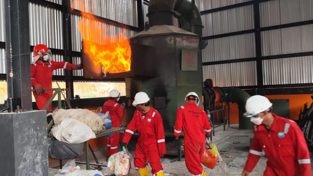 PEKERJA: Beberapa petugas memasukkan sampah ke tungku insinerator Wisanggeni 2 di kelurahan Baqa, Kecamatan Samarinda Seberang. (Foto: Denny Saputra/Kaltim Post) 