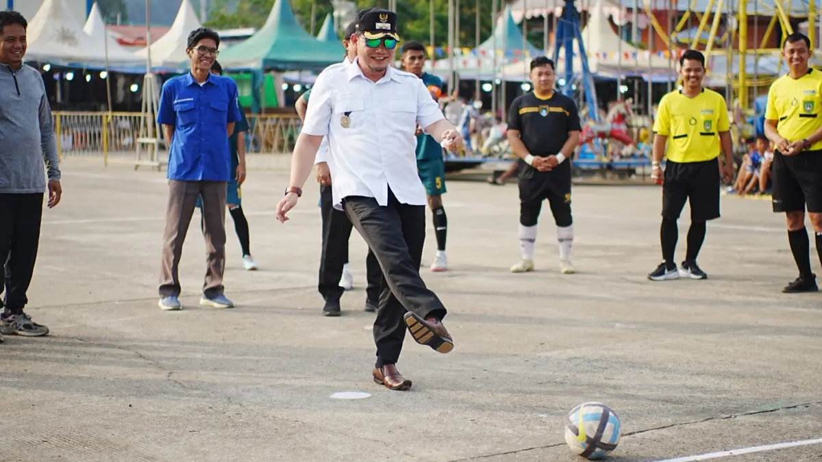 SEMARAK: Wakil Bupati Mahulu Suhuk menendang bola futsal tanda mulainya agenda Semarak HUT RI ke-81 di Lapangan Cor Ujoh Bilang, Rabu (12/8). (JODY KRISTIANTO/KP)